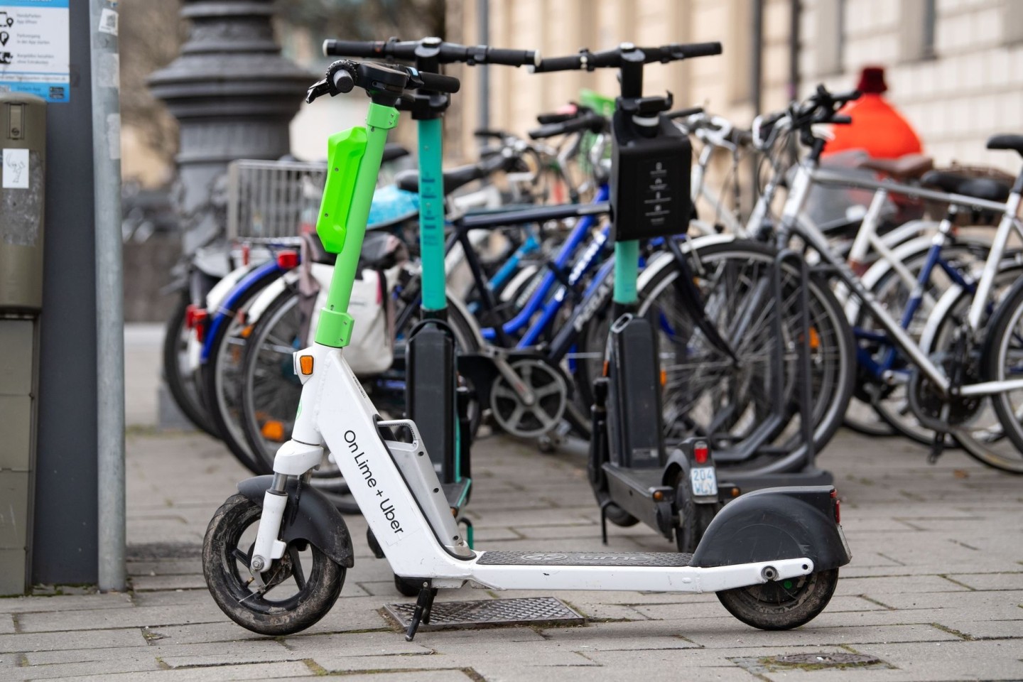E-Scooter stehen in der Münchener Innenstadt auf einem Gehweg.