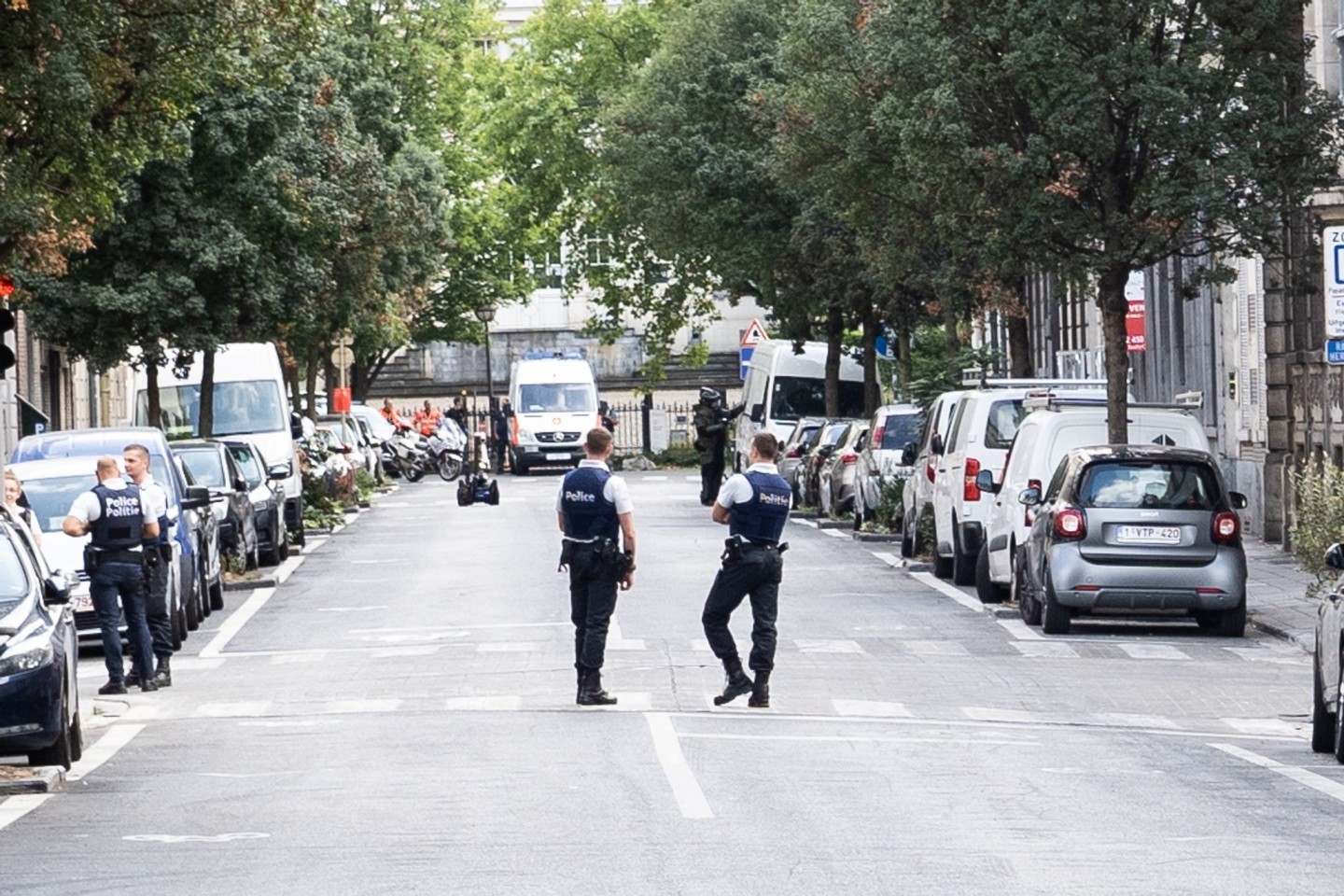 Zwei Polizisten stehen auf der Straße in Brüssel, wo der Lieferwagen gefunden wurde, der zuvor in zwei Terrassen gefahren war.
